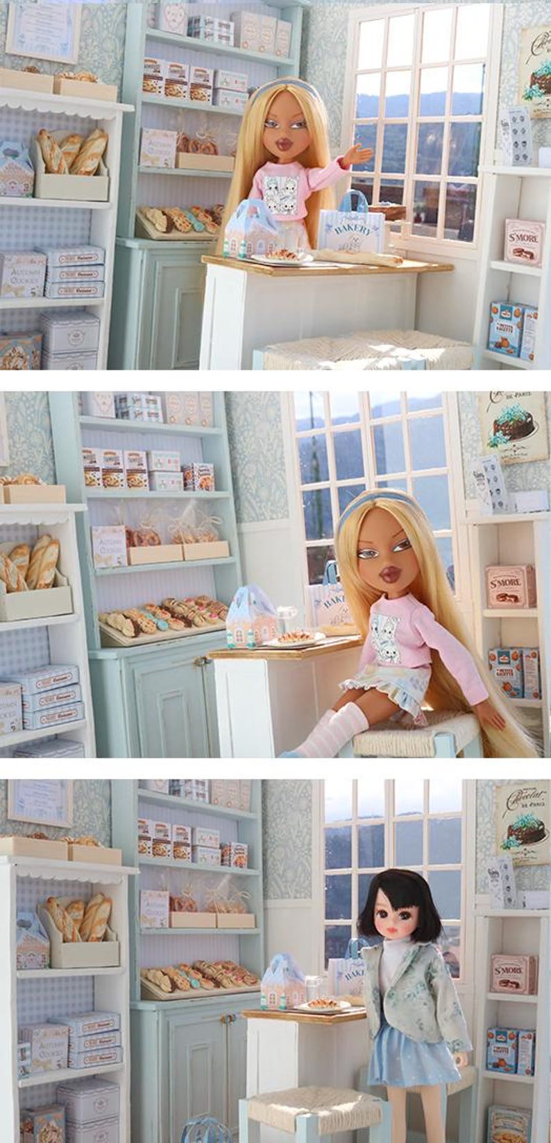 May include: A miniature bakery playset featuring shelves stocked with small boxes of cookies, bread loaves, and pastries. The scene includes a counter, a window, and a doll with long blonde hair wearing a pink long-sleeve shirt and a patterned skirt.