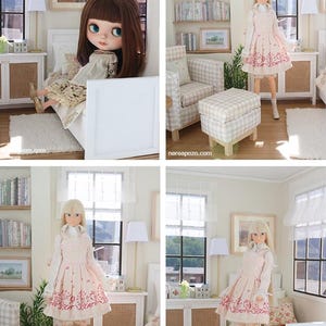K&ouml;nnte beinhalten: Ein Puppenhauszimmer mit einem wei&szlig;en Bett, einem karierten Sessel mit passendem Hocker und einem B&uuml;cherregal. Die Szene zeigt eine Puppe mit langem blonden Haar in einer wei&szlig;en Bluse und einem rosa Kleid mit roten Blumenmustern sowie eine braunhaarige Puppe.