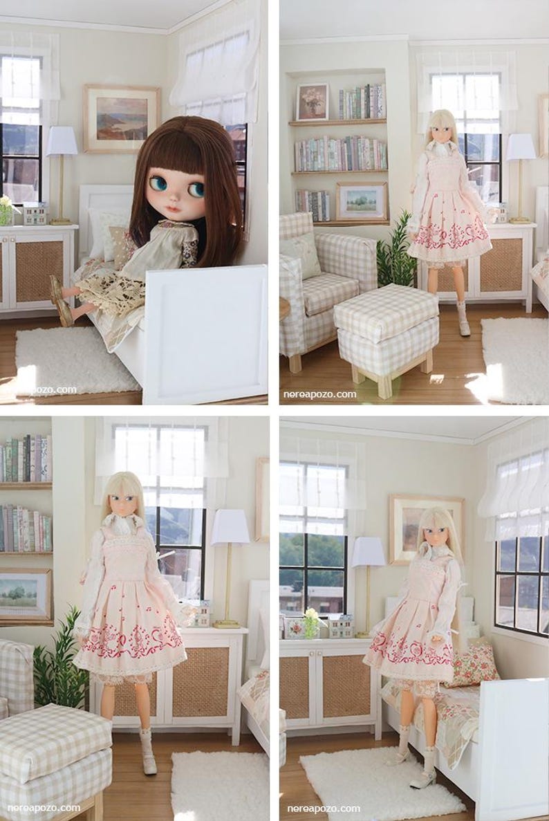 K&ouml;nnte beinhalten: Ein Puppenhauszimmer mit einem wei&szlig;en Bett, einem karierten Sessel mit passendem Hocker und einem B&uuml;cherregal. Die Szene zeigt eine Puppe mit langem blonden Haar in einer wei&szlig;en Bluse und einem rosa Kleid mit roten Blumenmustern sowie eine braunhaarige Puppe.