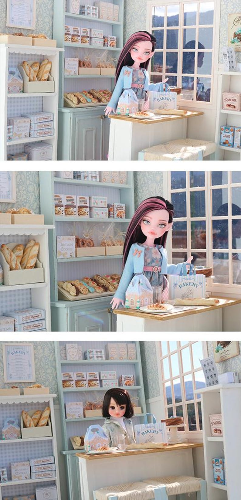 May include: A miniature bakery scene featuring a doll with long dark hair and pink highlights, wearing a light blue cardigan over a floral dress. The doll stands at a wooden counter with a small paper bag labeled Bakery and a pastry on a plate.