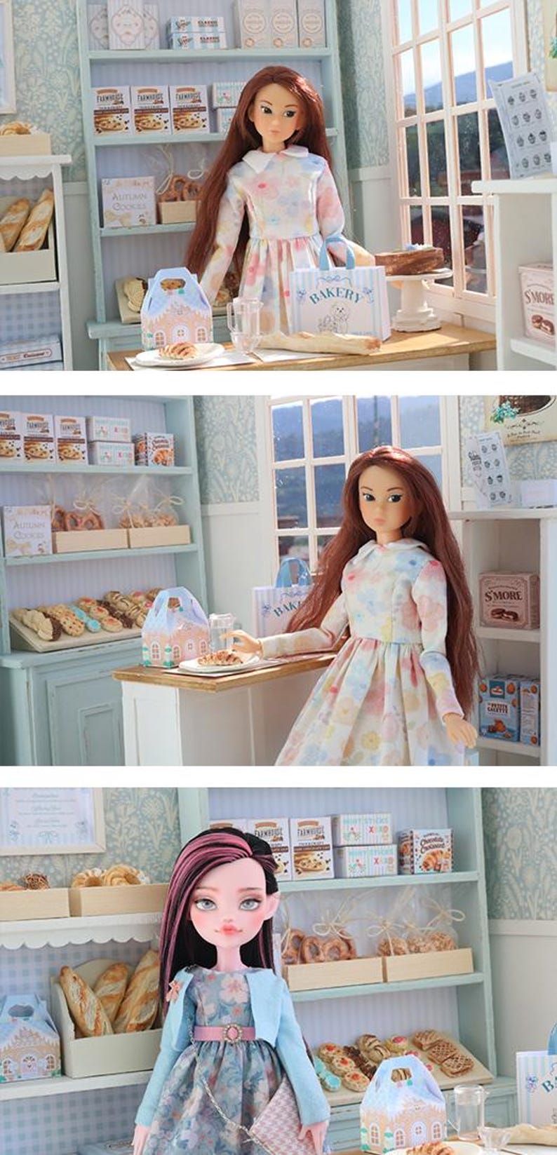 May include: A doll with long brown hair wearing a white dress with a pastel floral pattern stands in a miniature bakery setting. The scene includes shelves stocked with small boxes of cookies, pastries, and a blue and white bakery shopping bag.