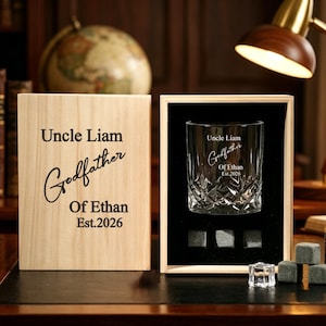 Peut inclure: Un ensemble cadeau comprenant un verre à whisky personnalisé et une boîte en bois. Le verre et la boîte sont gravés du texte "Uncle Liam Godfather Of Ethan Est.2026". L'ensemble comprend des pierres à whisky et une petite bouteille de whisky.