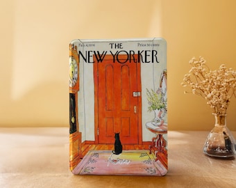 May include: A rectangular metal tin featuring a reproduction of The New Yorker magazine cover from Feb. 4, 1974. The illustration depicts a black cat sitting before a large orange door, a grandfather clock, and a small table with a floral vase.