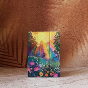 May include: A tablet case featuring a vibrant landscape painting. The artwork depicts a sunny scene with a bright yellow sun, colorful rays, and a field of flowers. The case is designed to protect the tablet while showcasing the colorful art.