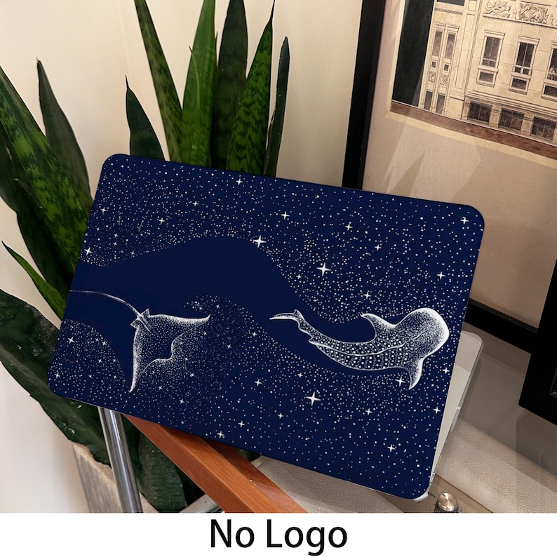 May include: A navy blue laptop case with a white illustration of a manta ray and a whale shark against a starry night sky. The case is designed to protect a laptop and has a smooth finish.