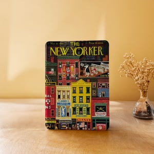 Puede incluir: Un objeto rectangular con una colorida ilustración de una escena callejera de Nueva York, con el texto "THE NEW YORKER" en la parte superior. La ilustración incluye la fecha "Mar. 18, 1944" y el precio "15 centavos".