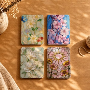 May include: Four rectangular cases featuring stained glass style floral designs. The top left shows white and blue flowers, the top right displays pink cherry blossoms, the bottom left depicts white magnolias, and the bottom right shows sunflowers.