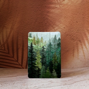 Può includere: Una custodia rettangolare con una scena di foresta con alti alberi sempreverdi in tonalità di verde e giallo. L'opera d'arte raffigura un paesaggio a strati con un cielo nebbioso azzurro chiaro. La custodia è posta su uno sfondo marrone strutturato.