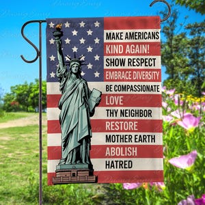 May include: A garden flag featuring the Statue of Liberty against a backdrop of the American flag. The flag includes the text: "Make Americans Kind Again! Show Respect, Embrace Diversity, Be Compassionate, Love Thy Neighbor, Restore Mother Earth, Abolish Hatred."