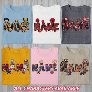 May include: Six folded t-shirts in various colors, each featuring a superhero-themed design with the word "NAME" in large, colorful letters. The shirts are light blue, white, gray, yellow, pink, and tan. The text "ALL CHARACTERS AVAILABLE" is at the bottom.