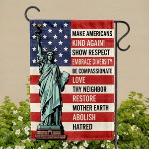 May include: A garden flag featuring the Statue of Liberty against a backdrop of the American flag. The flag includes the text: "MAKE AMERICANS KIND AGAIN! SHOW RESPECT, EMBRACE DIVERSITY, BE COMPASSIONATE, LOVE, THY NEIGHBOR, RESTORE MOTHER EARTH, ABOLISH HATRED."