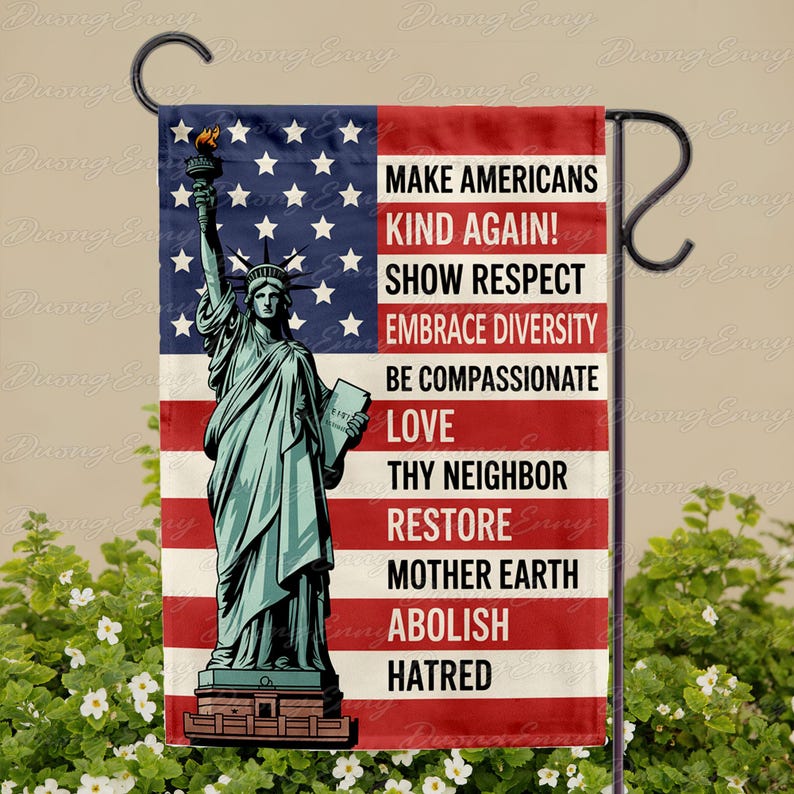 May include: A garden flag featuring the Statue of Liberty against a backdrop of the American flag. The flag includes the text: "MAKE AMERICANS KIND AGAIN! SHOW RESPECT, EMBRACE DIVERSITY, BE COMPASSIONATE, LOVE, THY NEIGHBOR, RESTORE MOTHER EARTH, ABOLISH HATRED."