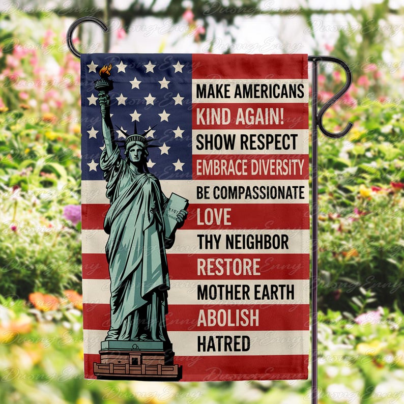 May include: A garden flag featuring the Statue of Liberty against a backdrop of the American flag. The flag includes the text: "MAKE AMERICANS KIND AGAIN! SHOW RESPECT, EMBRACE DIVERSITY, BE COMPASSIONATE, LOVE, THY NEIGHBOR, RESTORE MOTHER EARTH, ABOLISH HATRED."