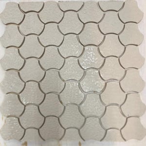Pode incluir: Uma folha de azulejos de cer&acirc;mica branca com um padr&atilde;o em forma de leque. Os azulejos s&atilde;o dispostos em um padr&atilde;o repetitivo.