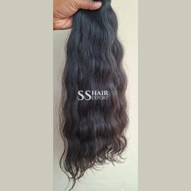Pu&ograve; includere: Extension di capelli ondulati scuri tenute da una mano. I capelli sono di un nero intenso con un motivo ondulato naturale. L'immagine include il testo "SS HAIR EXPORT".