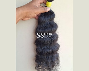 Könnte beinhalten: Ein Bündel dunkler, welliger Haare, gehalten von einer Hand. Das Haar ist oben mit einem gelben Band zusammengebunden. Der Text "SS HAIR EXPORT" ist auf dem Haar zu sehen.