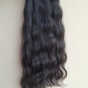 Pu&ograve; includere: Fascio di extension per capelli scuri e ondulati. I capelli sono di un nero intenso e hanno un motivo ondulato naturale. Le extension sono tenute insieme da una fascia trasparente. I capelli sembrano essere di alta qualit&agrave; e adatti a varie opzioni di styling.