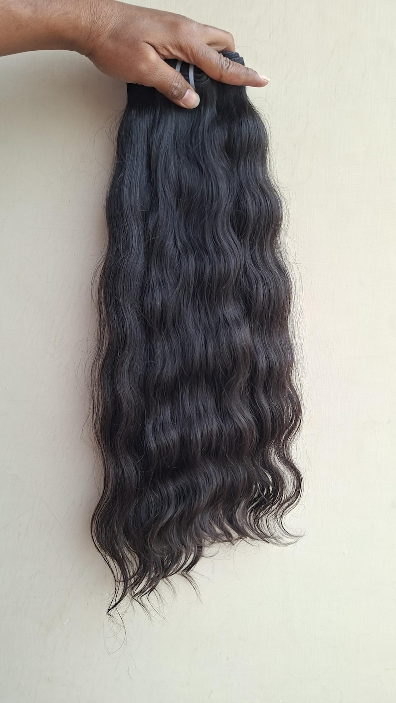 Pu&ograve; includere: Fascio di extension per capelli scuri e ondulati. I capelli sono di un nero intenso e hanno un motivo ondulato naturale. Le extension sono tenute insieme da una fascia trasparente. I capelli sembrano essere di alta qualit&agrave; e adatti a varie opzioni di styling.