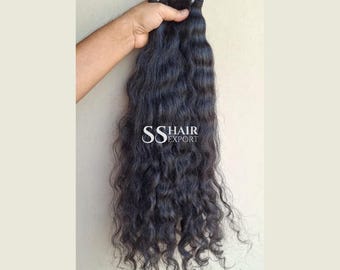 Könnte beinhalten: Ein Bündel langer, dunkler, gewellter Haarverlängerungen mit einer Tresse am oberen Ende. Das Haar hat eine natürliche Textur und eine tiefschwarze Farbe. Der Text SS HAIR EXPORT ist in Weiß in der Mitte des Haarbündels aufgedruckt.