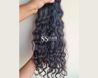 Könnte beinhalten: Ein Bündel langer, dunkler, gewellter Haarverlängerungen mit natürlicher Textur. Das Haar ist oben mit einem dicken, dunklen Band befestigt. Der Text SS HAIR EXPORT ist in Weiß in der Mitte des Haarbündels aufgedruckt und zeigt den Markennamen.