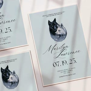 May include: Light blue wedding invitations with a black and white wolf illustration. The invitations include the names "Marilyn Lawrence" and the date "07.19.25". Text at the top reads "Join us in celebrating the balance of love - light and dark, becoming one."
