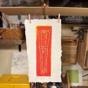 Light Red on Yellow Carrots on handmade paper made from recycled shredded IEPs.