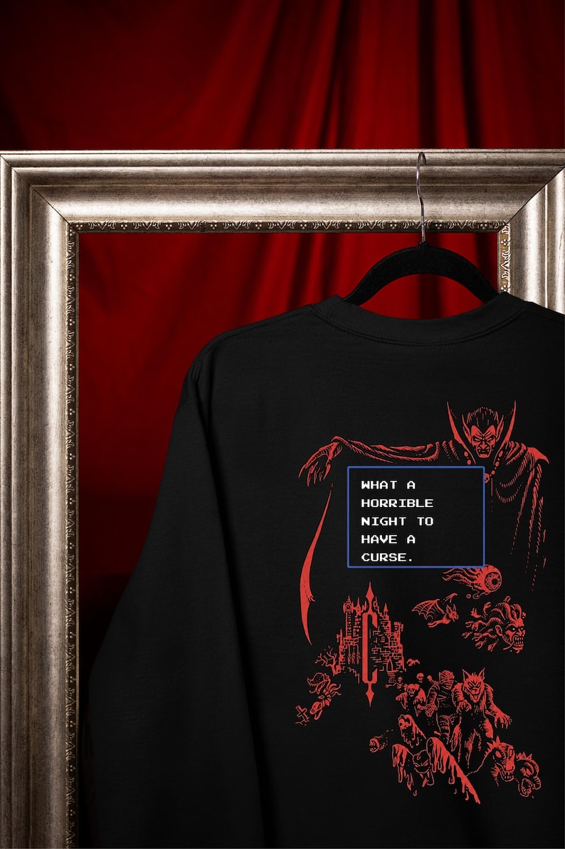 Close-up of red vampire, castle, and monster DTG print on a black Comfort Colors graphic tee.