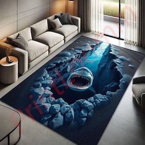 May include: A blue and gray area rug with a 3D image of a shark with its mouth open, appearing to be swimming out of a crack in the ocean floor.