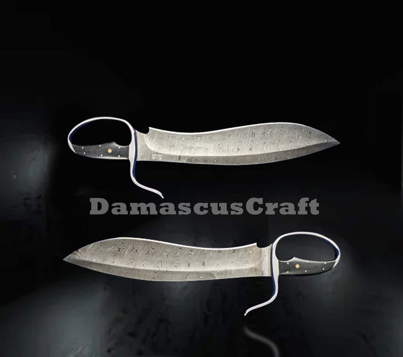 Op de afbeelding: Twee Damascus stalen messen met gebogen lemmeten en lusvormige handvatten worden getoond tegen een zwarte achtergrond. De lemmeten hebben een uniek patroon en de handvatten zijn zwart met gouden accenten. De tekst "DamascusCraft" is zichtbaar.