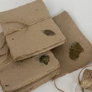 Papel reciclado con elementos naturales, hecho a mano. 5 hojas, tamaño A6. Bordes irregulares propios de este tipo de papel. Varios modelos.