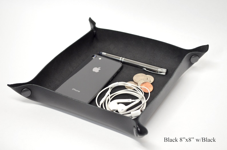 Puede incluir: Bandeja de cuero negro con esquinas redondeadas y forro de fieltro negro. La bandeja mide 20,3 cm por 20,3 cm y tiene un tel&eacute;fono, un bol&iacute;grafo y auriculares en su interior.