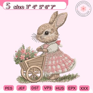 Könnte beinhalten: Gesticktes Design eines Hasen, der eine Schubkarre mit Blumen schiebt. Der Hase trägt ein rosa-weißes Kleid. Erhältlich in Größen von 7,6 cm bis 17,8 cm.