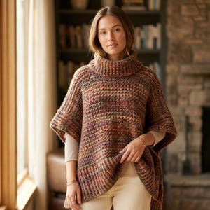 May include: A multi-colored knit poncho featuring a thick turtleneck collar and short sleeves. The garment is crafted from a textured yarn blend in shades of brown, rust, green, and cream, with a ribbed hemline and a loose, relaxed fit.