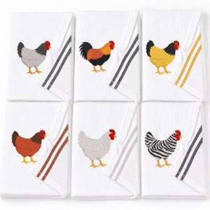 May include: A set of six white kitchen towels, each featuring an embroidered chicken in a different color or pattern, including gray, brown, yellow, and black-and-white stripes. Each towel has two vertical stripes along the edge in matching colors.