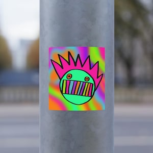 May include: A square sticker featuring a cartoon face with a green head, pink spiky hair, and a colorful striped mouth. The background is a vibrant, psychedelic swirl of orange, pink, green, and purple. The sticker is affixed to a gray metal pole.