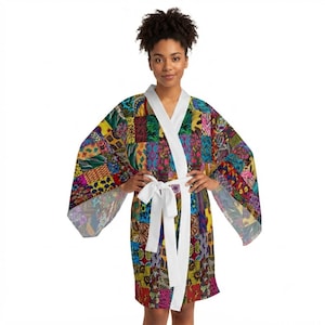 May include: A kimono-style robe featuring a vibrant, multi-colored patchwork pattern with various geometric and organic shapes. The garment has wide sleeves, a solid white collar, and a matching white fabric tie belt at the waist.