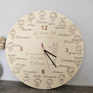 Può includere: Un orologio in legno con dettagli incisi. Il quadrante presenta personaggi dei cartoni animati sul perimetro, con nomi e numeri. Il testo "La classe 1A 2024-2025" è visibile. Le lancette dell'orologio sono nere con una lancetta dei secondi rossa.