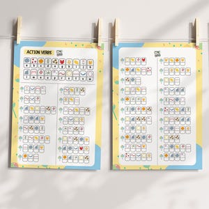 May include: Two educational posters titled "Action Verbs" are displayed. Each poster features a yellow background with blue and pastel-colored accents. The posters are held by wooden clothespins. The posters contain colorful illustrations and the alphabet.