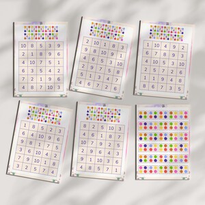 May include: Six printed worksheets with number grids and colorful dot patterns. Each worksheet features a different arrangement of numbers from 1 to 10, designed for educational activities. The top of each sheet has a colorful dot pattern.