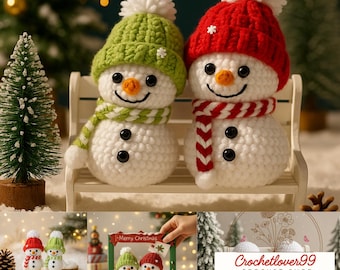 May include: Two crocheted snowmen with white bodies, black button eyes, and orange carrot noses. One snowman wears a green hat and scarf, the other a red hat and scarf. Both have white pom-poms and are sitting on a small bench.