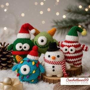 Könnte beinhalten: Fünf gehäkelte Weihnachtsfiguren, darunter ein Schneemann und verschiedene Monster, die jeweils festliche Hüte tragen. Die Figuren sind in Rot-, Grün-, Blau- und Weißtönen gehalten und mit Lichterketten und anderen saisonalen Dekorationen versehen.