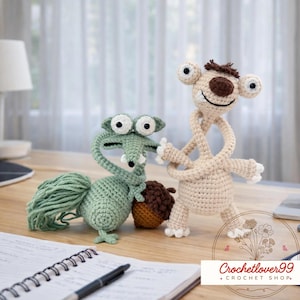 Könnte beinhalten: Zwei gehäkelte Zeichentrickfiguren, ein grünes eichhörnchenartiges Wesen mit einem großen Schwanz und ein beigefarbenes Faultier, stehen auf einer Holzoberfläche. Das Eichhörnchen hält eine braune Eichel. Das Faultier hat eine braune Nase und Haare.