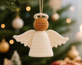 May include: A crocheted angel Christmas ornament. The angel has a tan head and halo, with cream-colored wings and body. The ornament is hanging from a gold string against a blurred Christmas tree background. The shop name "Crochetlover99" is visible.