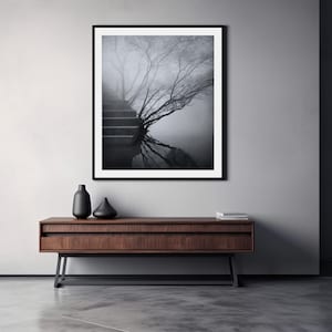Könnte beinhalten: Ein Schwarzweißfoto von einer Treppe, die zu einem Baum in einem nebligen Wald führt. Die Äste des Baumes spiegeln sich im Wasser darunter.