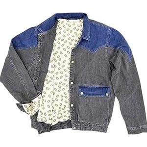 Puede incluir: Chaqueta vaquera de dos tonos. Los hombros y las solapas de los bolsillos son de color azul oscuro, contrastando con el cuerpo gris descolorido. Presenta una botonadura y un forro crema con estampado.