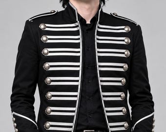 May include: A black military-style jacket featuring silver-toned metallic buttons arranged in two vertical rows. The garment is accented with horizontal silver piping across the chest and shoulders, a high collar, and matching silver piping on the cuffs.