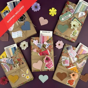 May include: Several wrapped gifts with floral paper and twine, decorated with heart-shaped leather accents and stickers. Each package contains a reading list and other stationery items. Scattered around are artificial flowers.