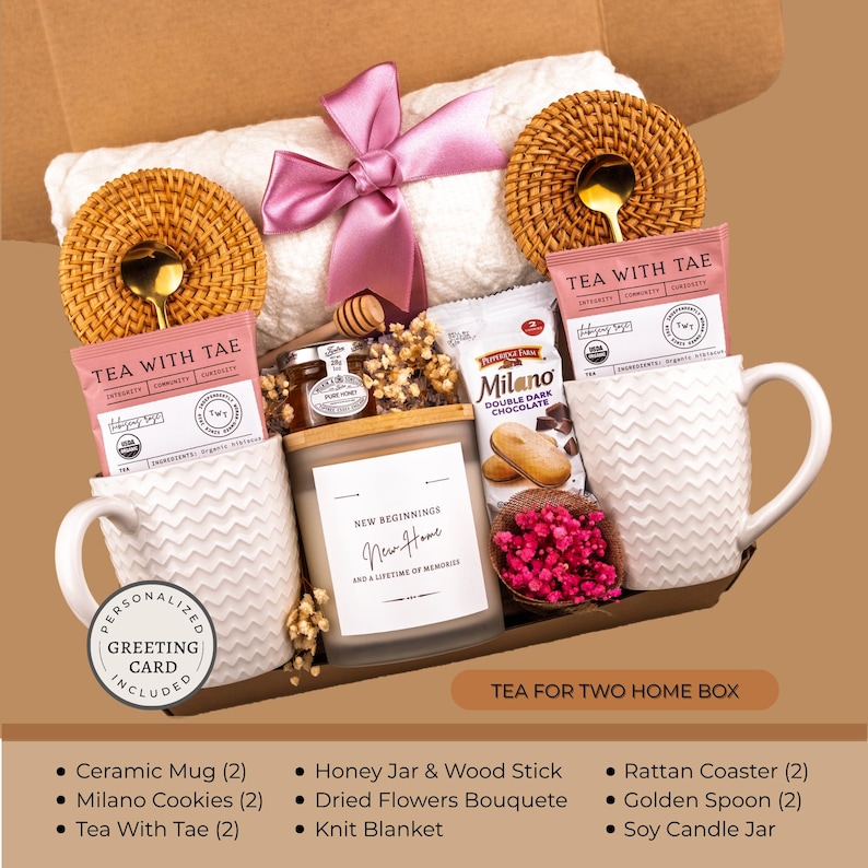 Peut inclure: Un coffret cadeau avec une couverture en tricot blanche, deux tasses en c&eacute;ramique blanches, des sachets de th&eacute;, des biscuits Milano, un pot de miel, une bougie et un petit bouquet de fleurs roses. Comprend des dessous de verre en rotin, des cuill&egrave;res dor&eacute;es et une carte de v&oelig;ux personnalis&eacute;e.