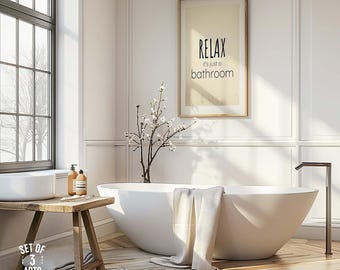 May include: A bright, modern bathroom with a white, oval-shaped bathtub and a framed print that reads "RELAX, it's just a bathroom." A wooden bench holds a sink and toiletries. A towel hangs over the tub's edge. The room has a large window.