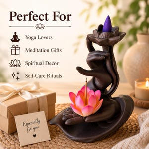 May include: A dark brown ceramic incense burner shaped like a hand holding a pink and orange lotus flower. A purple incense cone sits on a lotus-shaped top. The text reads: Perfect For, Yoga Lovers, Meditation Gifts, Spiritual Decor, Self-Care Rituals.